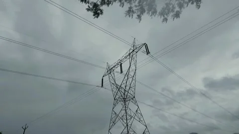 Electric pylon stands under overcast skies, its lines cutting through the thin r Stock Footage 341272218