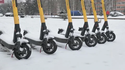 Electric scooters under the snow during a snowfall Stock Footage 225525858