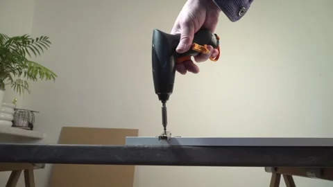 Electric screwdriver mounting a metal hinge on a white cabinet concept of D.. Stock Footage 330976277