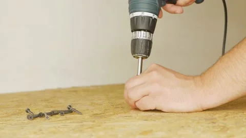 Electric screwdriver is screw in a screw into a oriented strand board. Stock Footage 202845977