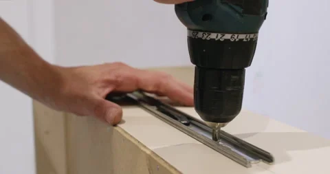 Electric screwdriver spins while screw exits metal rail smoothly Stock Footage 323967369