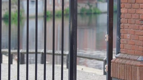 Electric Security Gate Closing Against Brick Wall in Urban Setting Stock Footage 317527666