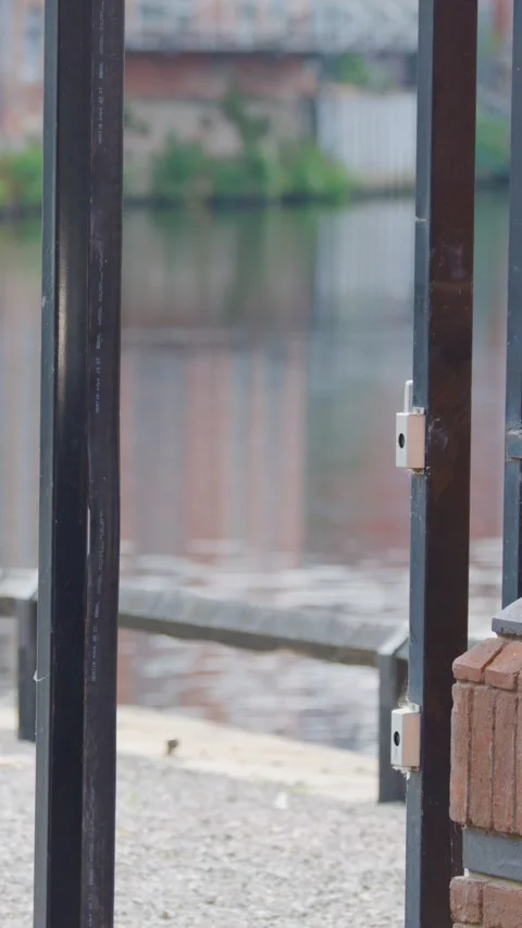 Electric Security Gate Closing Beside Riverside Brick Wall Stock Footage 315833546