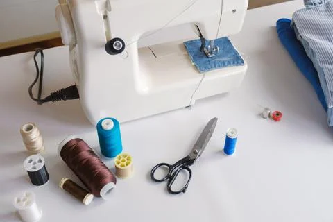 Electric sewing machine and spools of thread on the table Stockfoto's