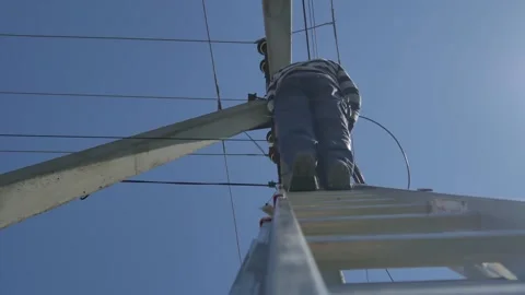 Electric silhouette worker engineer working on electric pole standing on stairs Stock Footage 149111761