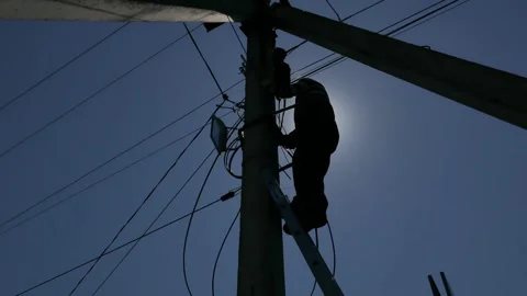 Electric silhouette worker engineer working on electric pole standing on stairs Stock Footage 149111769