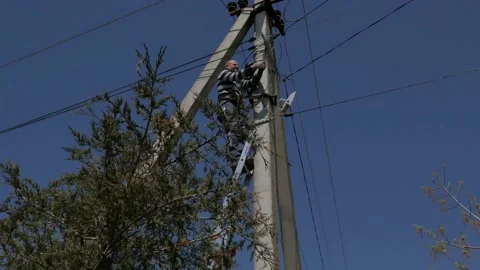 Electric silhouette worker engineer working on electric pole standing on stairs Stock Footage 150089401