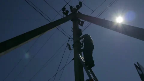 Electric silhouette worker engineer working on electric pole standing on stairs Stock Footage 150637942