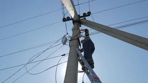Electric silhouette worker engineer working on electric pole standing on stairs Stock Footage 150640623