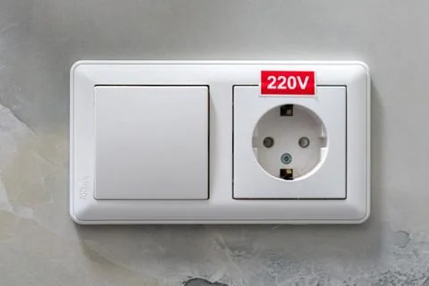 Electric socket and a switch on the wall of the hotel Stock Photos