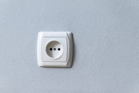 Electric socket mounted on grey wall at modern flat Stock Photos