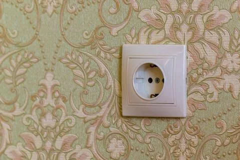 Electric socket on a wall with wallpaper Stock Photos