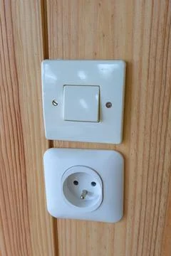 Electric socket white for plug cord electrical outlet and a switch on woode.. Stock Photos