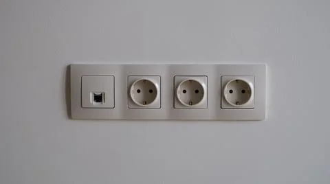 Electric socket on white wall closeup. Sockets with antenna cable and internet Foto stock