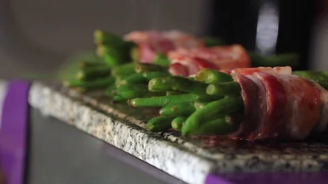 Electric stone cooking beans wrapped in bacon Stock Footage 71990928