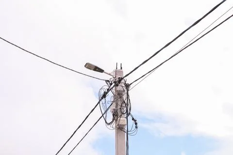 Electric street pole with complex network of tangled wires and cables, alon.. Foto stock