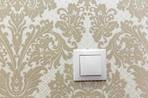 Electric switch on the wall on a background of sand colored Wallpaper with a  Stock Photos