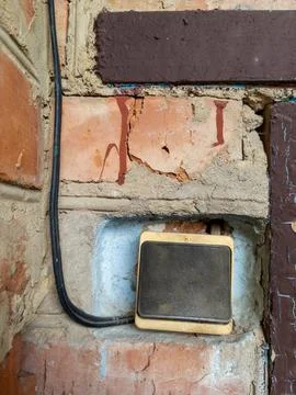 Electric switch with a wire on a brick wall Stock Photos