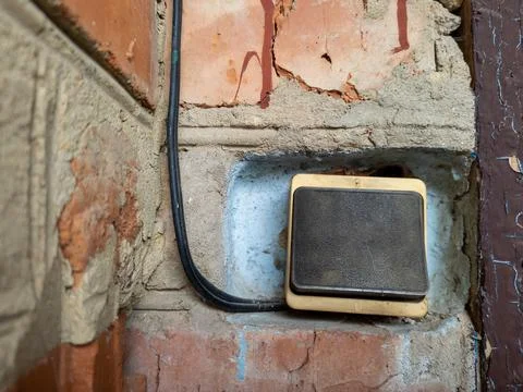 Electric switch with a wire on a brick wall Stock Photos