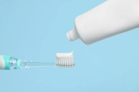 Electric toothbrush with paste on light blue background, closeup 스톡 사진