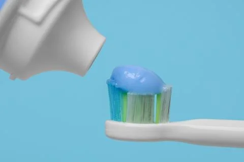 Electric toothbrush with paste on light blue background, closeup 스톡 사진