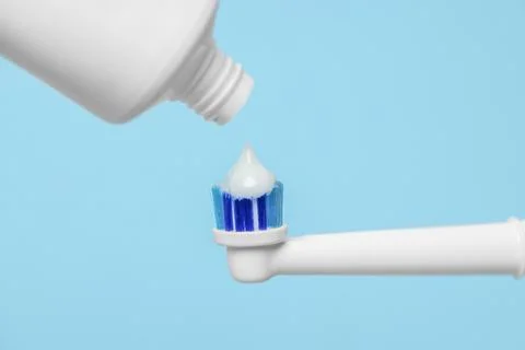 Electric toothbrush with paste on light blue background, closeup 스톡 사진