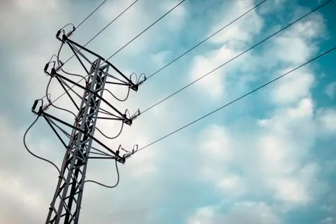 Electric tower with a background of clouds and blue sky. Stock Photos