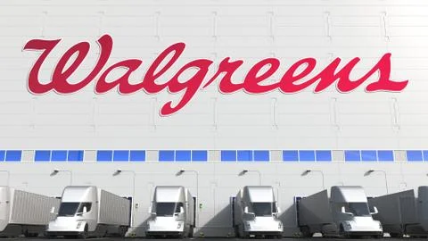Electric trailer trucks at warehouse loading bay with WALGREENS logo on the wall Ilustración de archivo