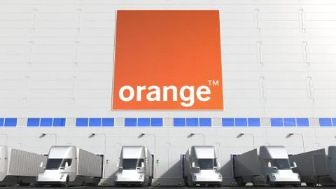Electric trailer trucks at warehouse loading bay with ORANGE S.A. logo on the Ilustración de archivo