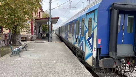Electric train departing from a small station in a Greek town Stock Footage 321950068