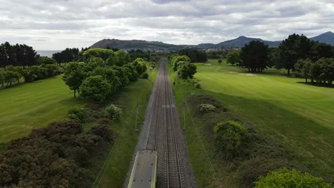 Electric train fly along behind through green countryside Stock Footage 133804496