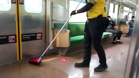 Electric train janitor cleans the floor of the train carriage Stock Footage 157086652
