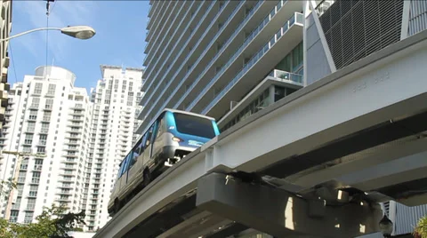 Electric Train passes infant of building in Downtown Miami Stock Footage 36640610