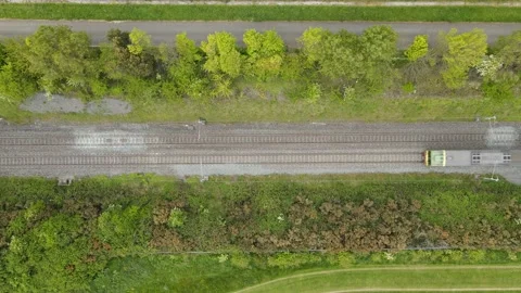 Electric train vertical from above through green countryside Stock Footage 133805049