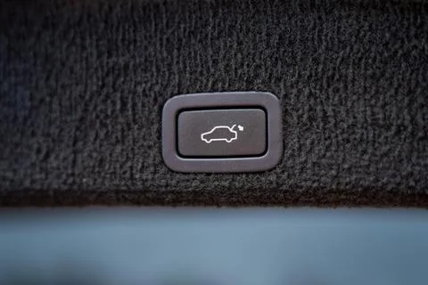 Electric trunk release button integrated into vehicle interior panel Stock Photos
