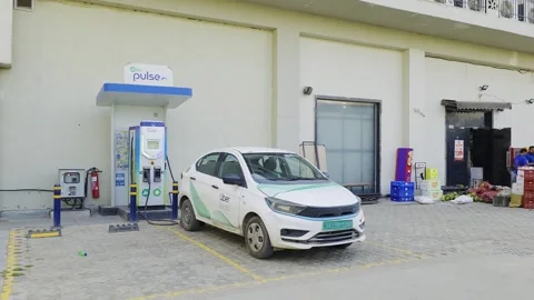 An electric Uber cab charges at a public Jio BP Pulse EV station in Delhi, Stock Footage 333009328