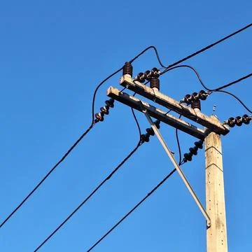 Electric utility pole under clear blue sky background Stock Photos