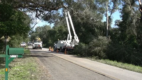 Electric Utility trucks working over rural road after Hurricane Mathue Stock Footage