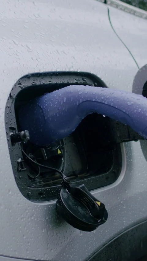 Electric vehicle charging connector inserted into car charging port during Stock-Footage 336545988