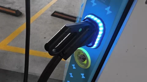 Electric vehicle charging plug connected to public charging station with 스톡 동영상 341657613