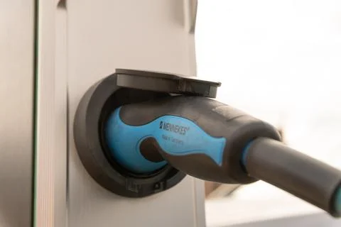 Electric vehicle charging plug inserted into station socket Stockfoto's