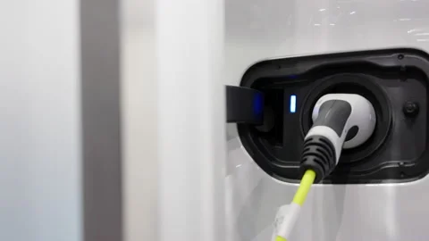 Electric vehicle charging port plugging in EV modern car Stock Footage 166678747