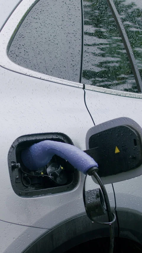 Electric vehicle charging process with a close-up view of the charging port and Stock Footage 336545961