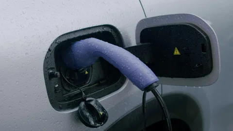 Electric vehicle charging process with a close-up view of a purple charging 库存影片 336547464