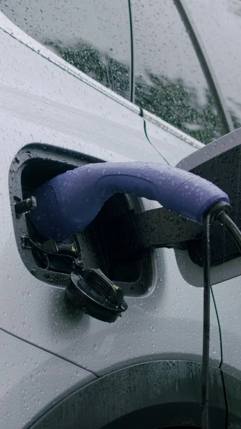 Electric vehicle charging process with a close-up view of the charging port and Stock Footage 340273899