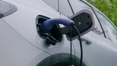 Electric vehicle charging process with a close-up view of the charging port and Stock Footage 340275745