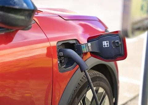 Electric vehicle charging process with plug connected to car port 库存照片