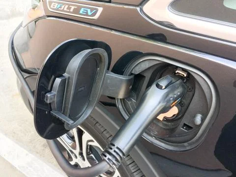 Electric vehicle charging while parked Stock Photos
