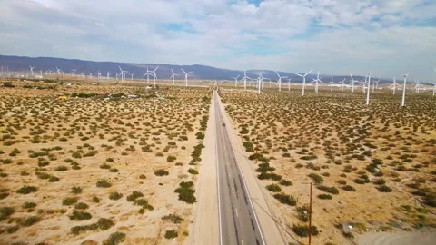 Electric Vehicle driving through Wind Farm and Solar Farm Video stock 333290780