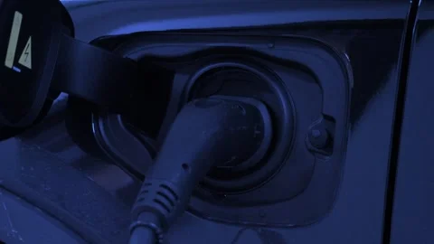 Electric vehicle or EV car charging at a station. with a glowing light indi.. Stock Footage 305501469